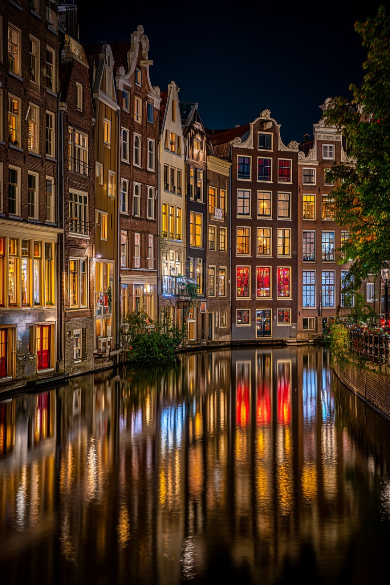 Amsterdamer Grachten mit stimmungsvoller Beleuchtung und Spiegelungen.